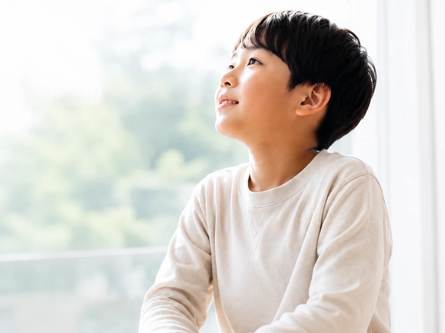 希望に満ちた表情で空を見上げる男の子